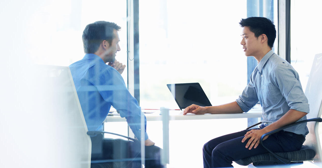 Two people discussing strategy in an office, representing GRE Verbal skill-building.